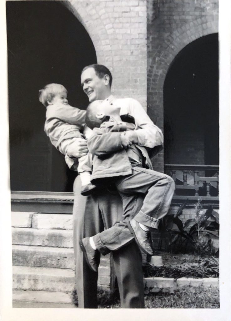Clovis holding John and Ben, next to the front porch steps