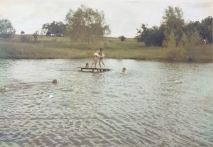 Playing “King of the Raft” at the farm. We are all wearing ski belts because that was the safety rule for everyone swimming.