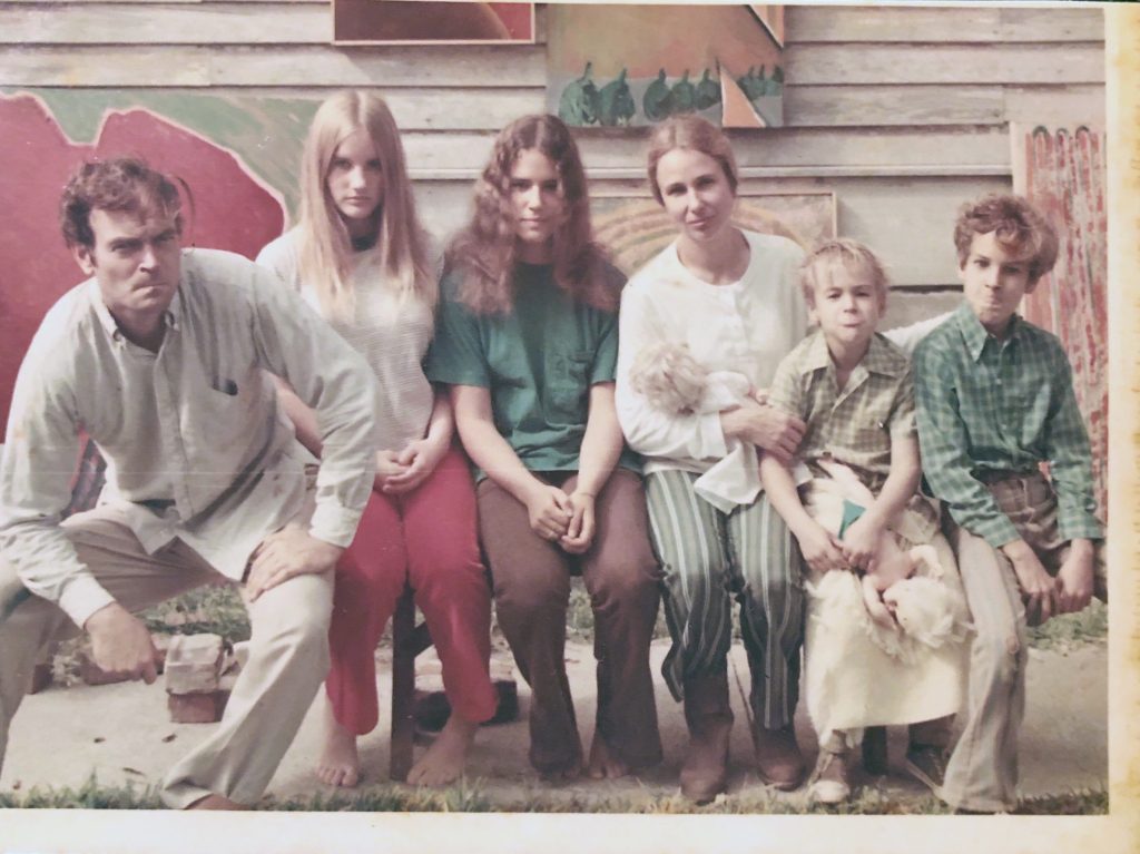 Heimsath family in front of Clovis's paintings looking grouchy