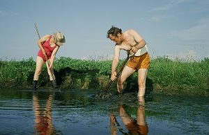 Clovis and I are raking up the weeds at the edge of the pond.
